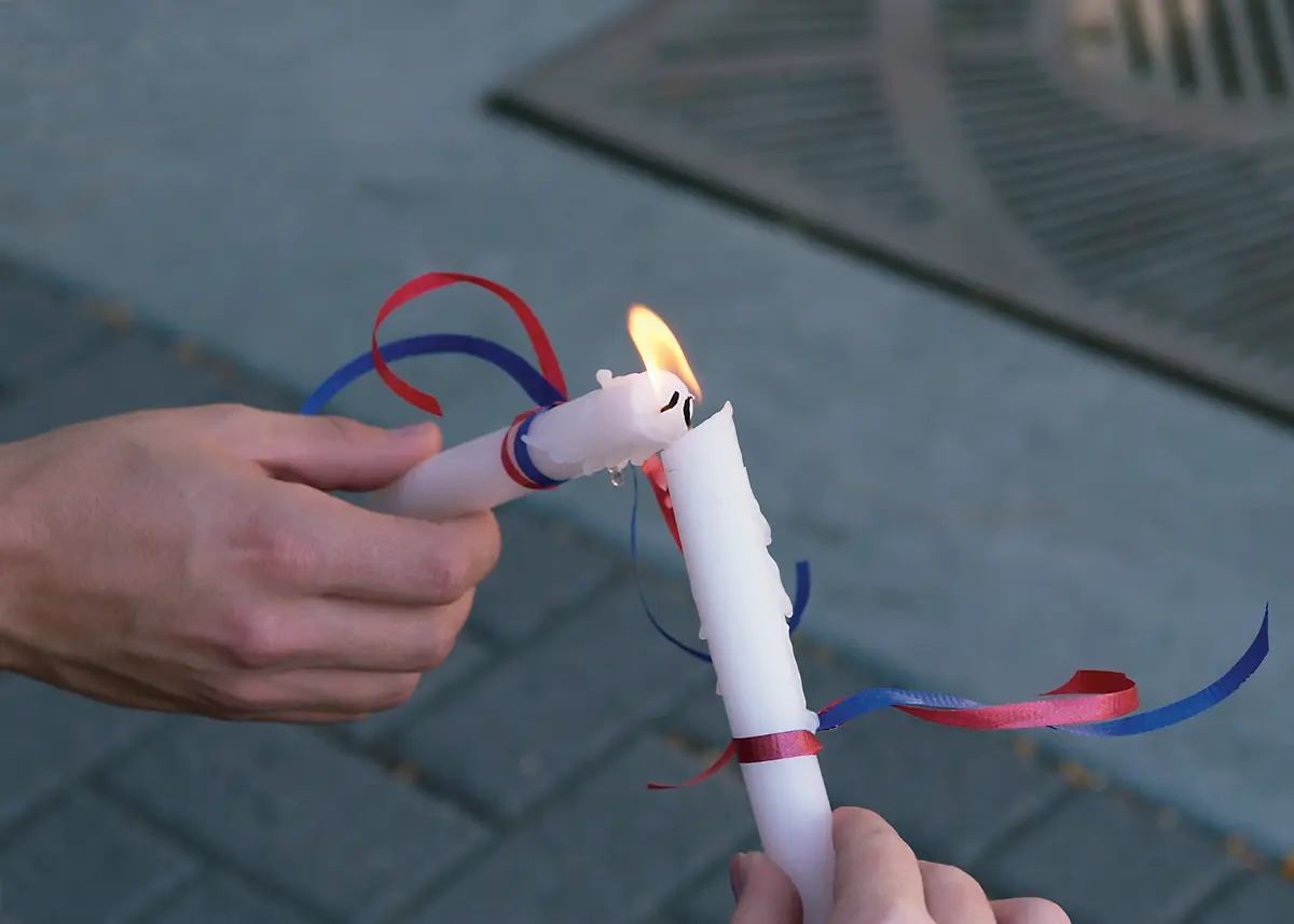 Two candles share a flame as their wicks touch during a candlelight vigil to commemorate the Sept. 11, 2001, terrorist attacks.