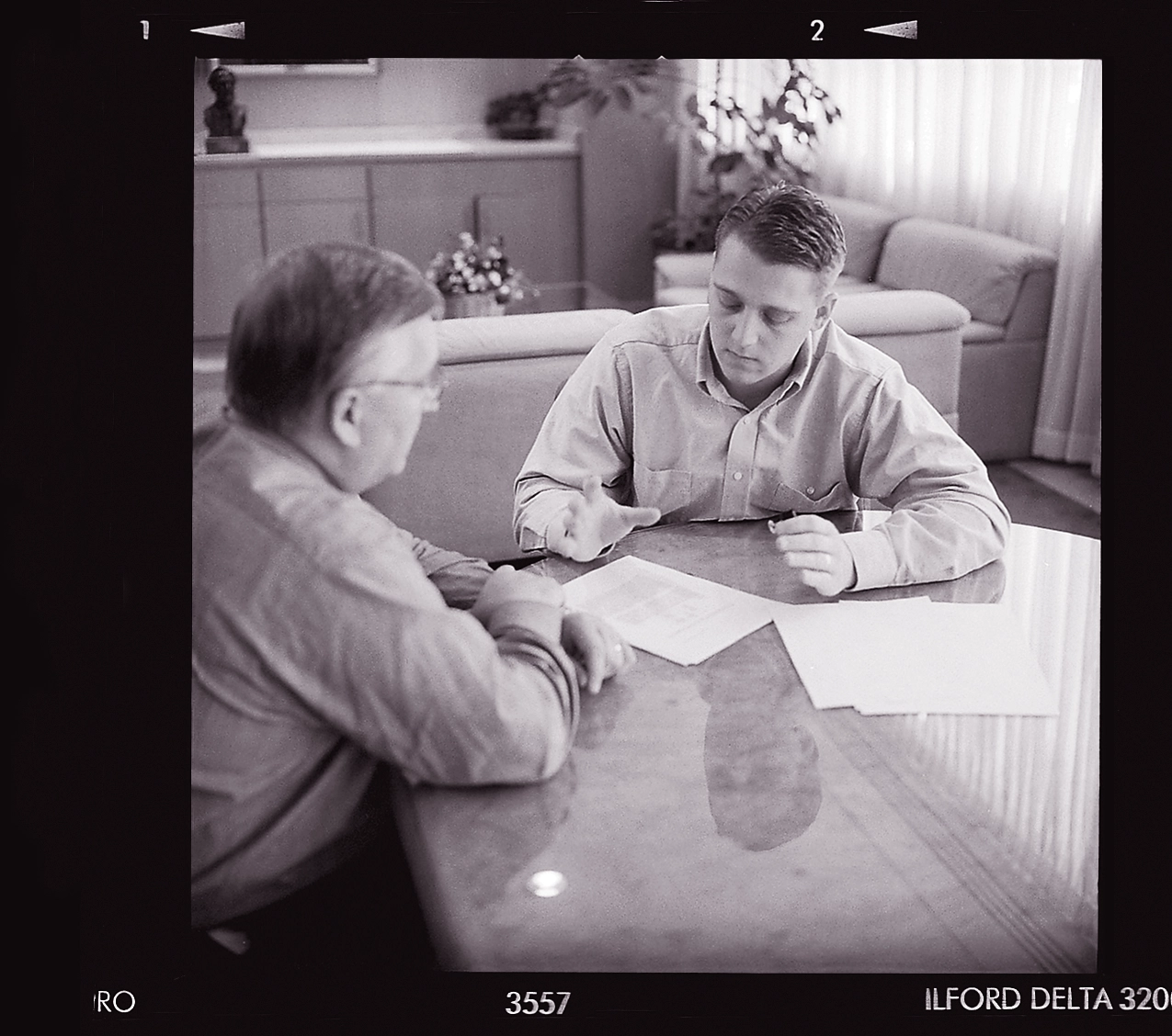 Albrecht sits at a table reviewing papers with his other son.