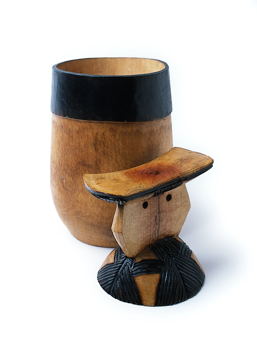 A tall wooden cup and a short wooden headrest for using as a pillow.