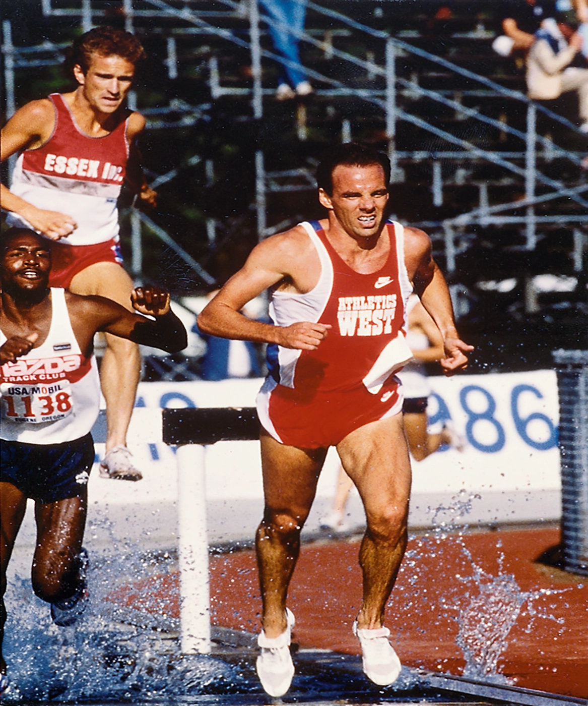 Henry Marsh running down a track with hurdles on it