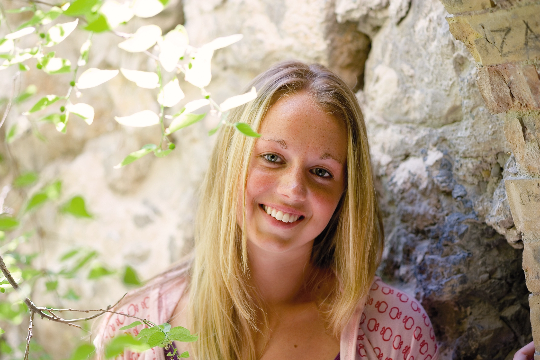 Kimberlee Couper leans against a rock.