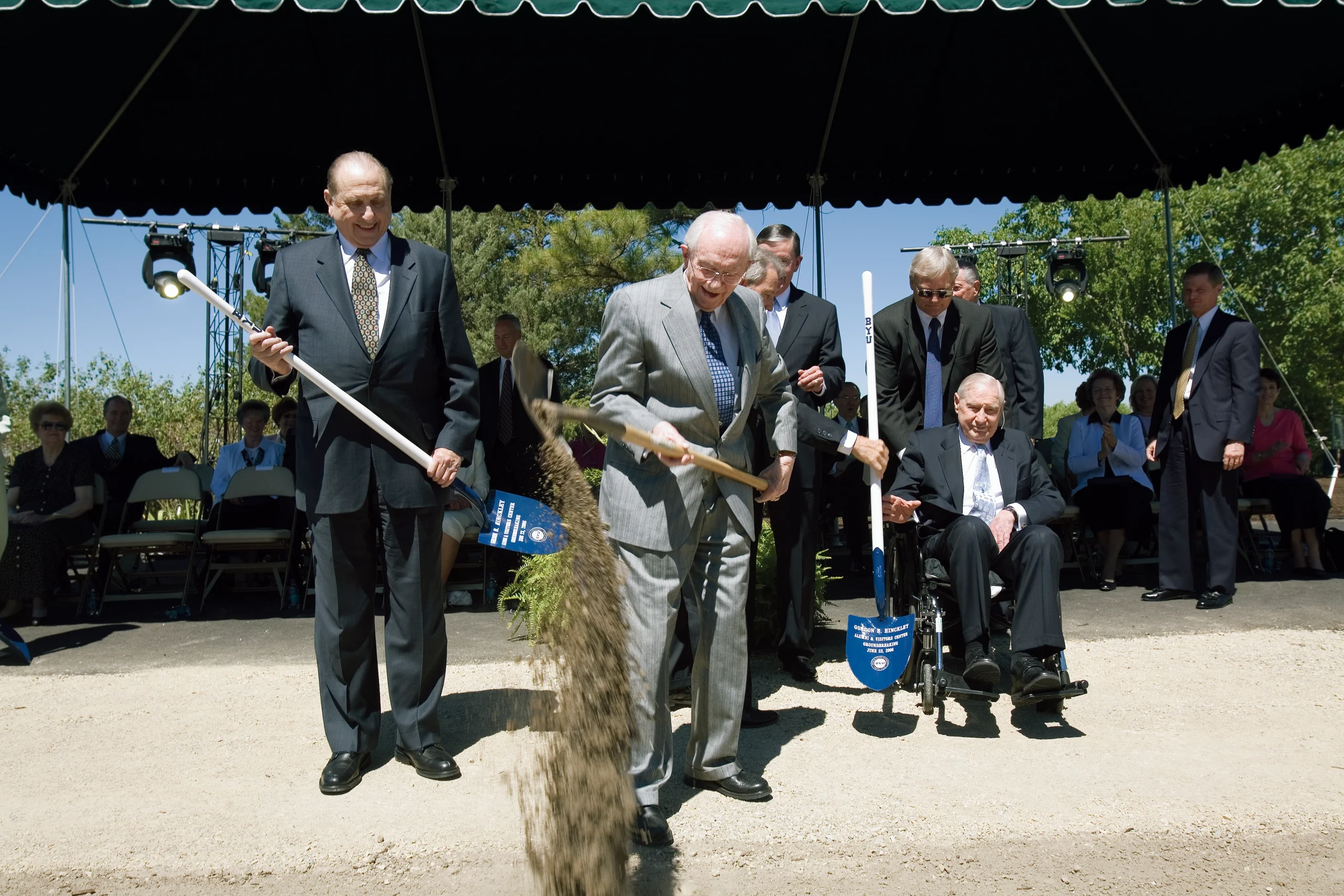President Hinckley overturns his shovelful of dirt to drop the dirt down.