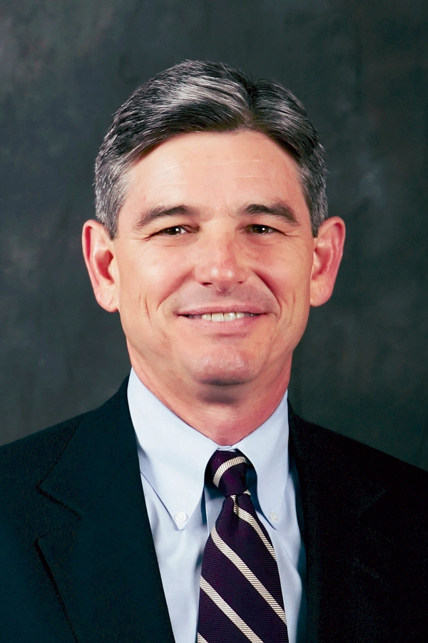 Craig McIlroy poses in a suit and tie.