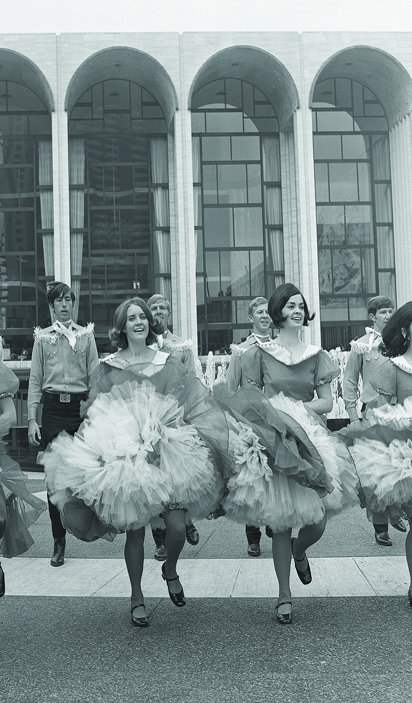 Black and white photo of BYU folk dancers dancing in the streets of New York City.