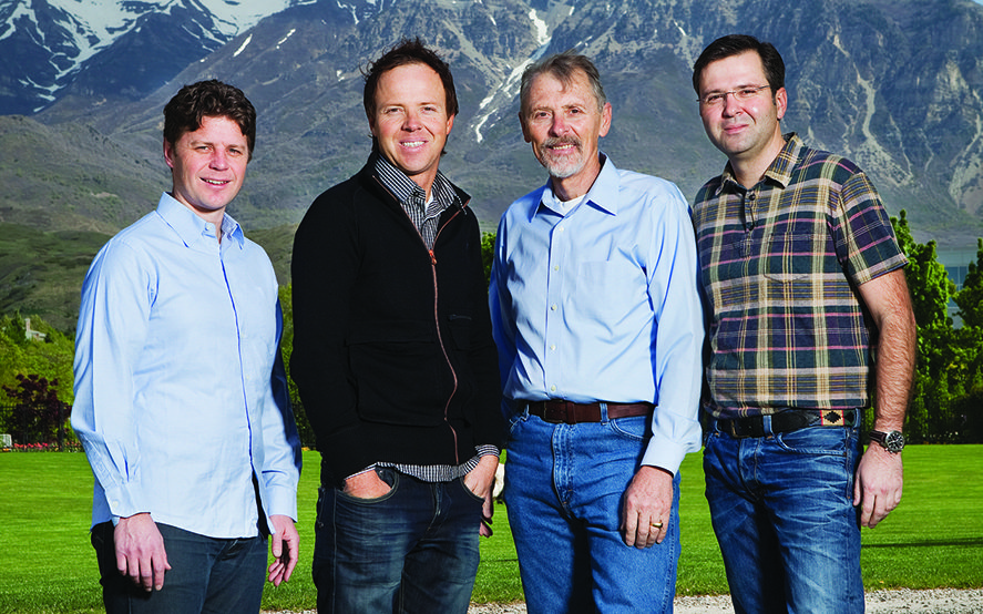 Qualtrics founders Stuart Orgill, Ryan Smith, Scott Smith, and Jared Smith stand next to each other in front of mountains.