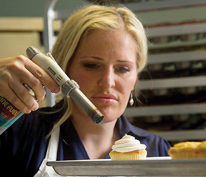 Megan Faulkner Brown uses a blowtorch to perfect a cupcake.