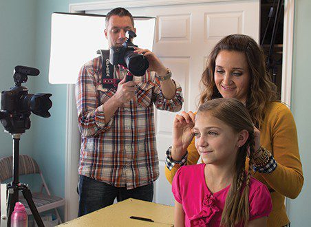 Mindy McKnight does her daughter&rsquo;s hair while dad, Shaun McKnight, films