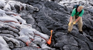 As graduate student Matthew P. Harper, '01, pulls fresh lava from an active flow, the orange goo stretches like warm molasses. Harper came to hawaii to study magmas related to his master's thesis research. 