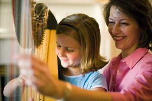 child playing harp with mother
