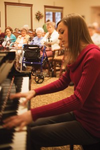 Arianna Sam ('13), a piano performance major from Vernal, Utah, performs at the Courtyard at Jamestown, an assisted living center in Provo. In addition to concerts, the Courtyard frequently hosts BYU students who adopt a grandparent and make weekly visits. 