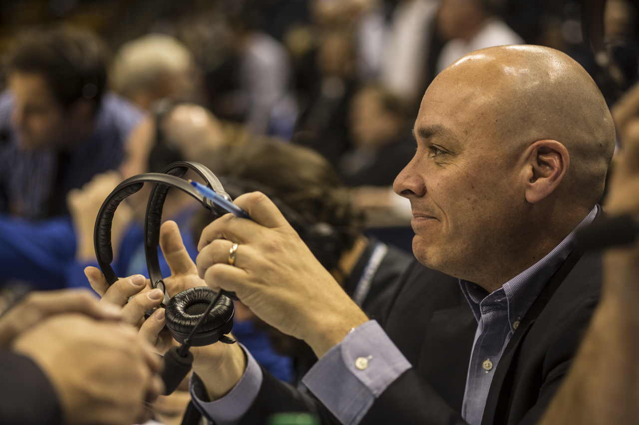Wrubell preps for a basketball game as he holds his headset.