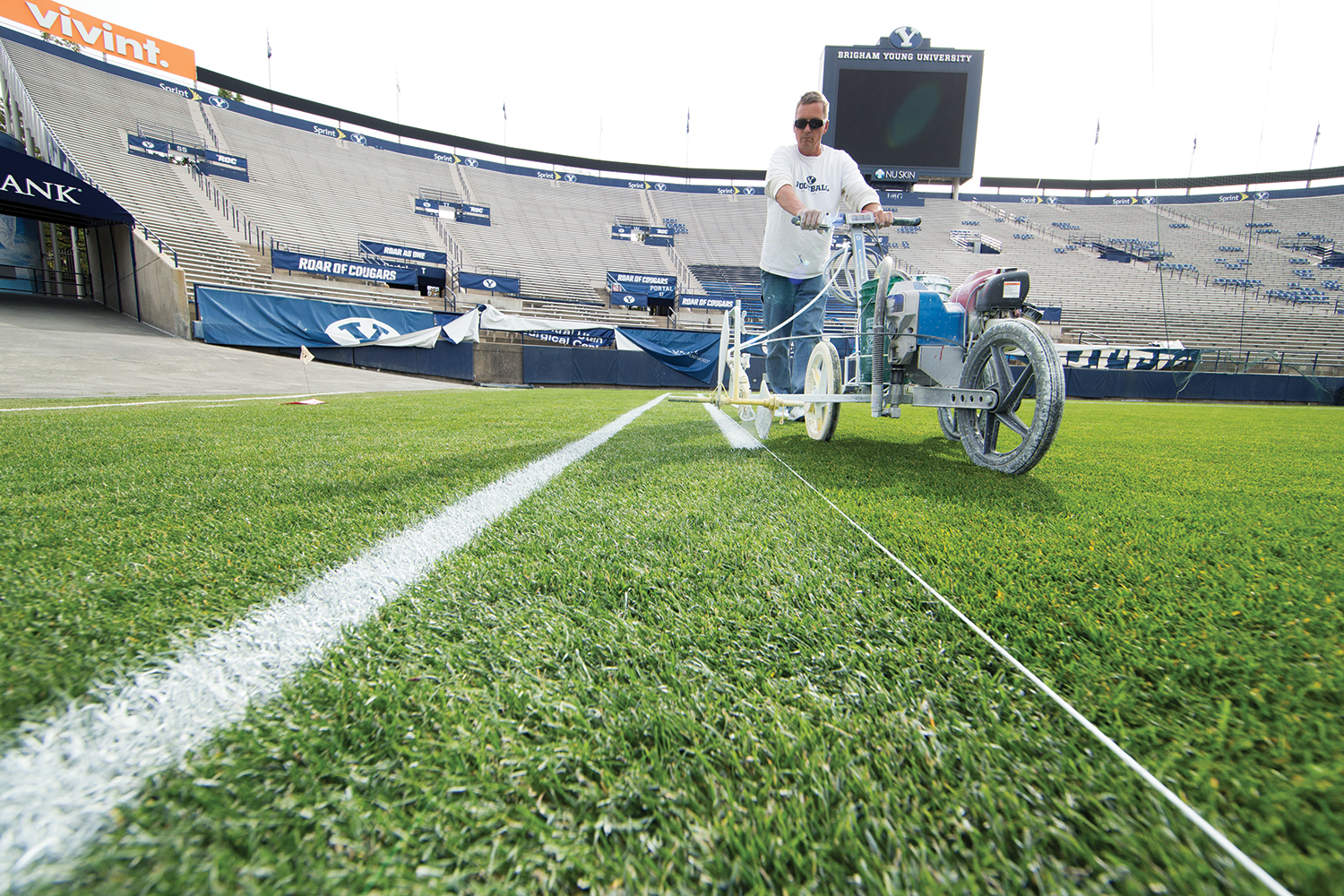 BYU employee Jon Quist prepares paints lines on the turf in preparation for an upcoming football game.