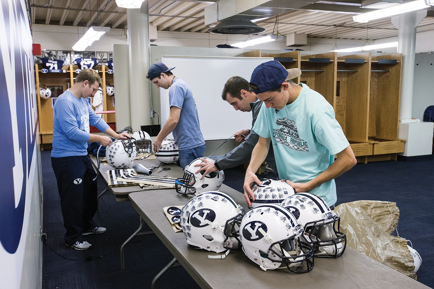 Student workers prepare football helmets for the upcoming game.