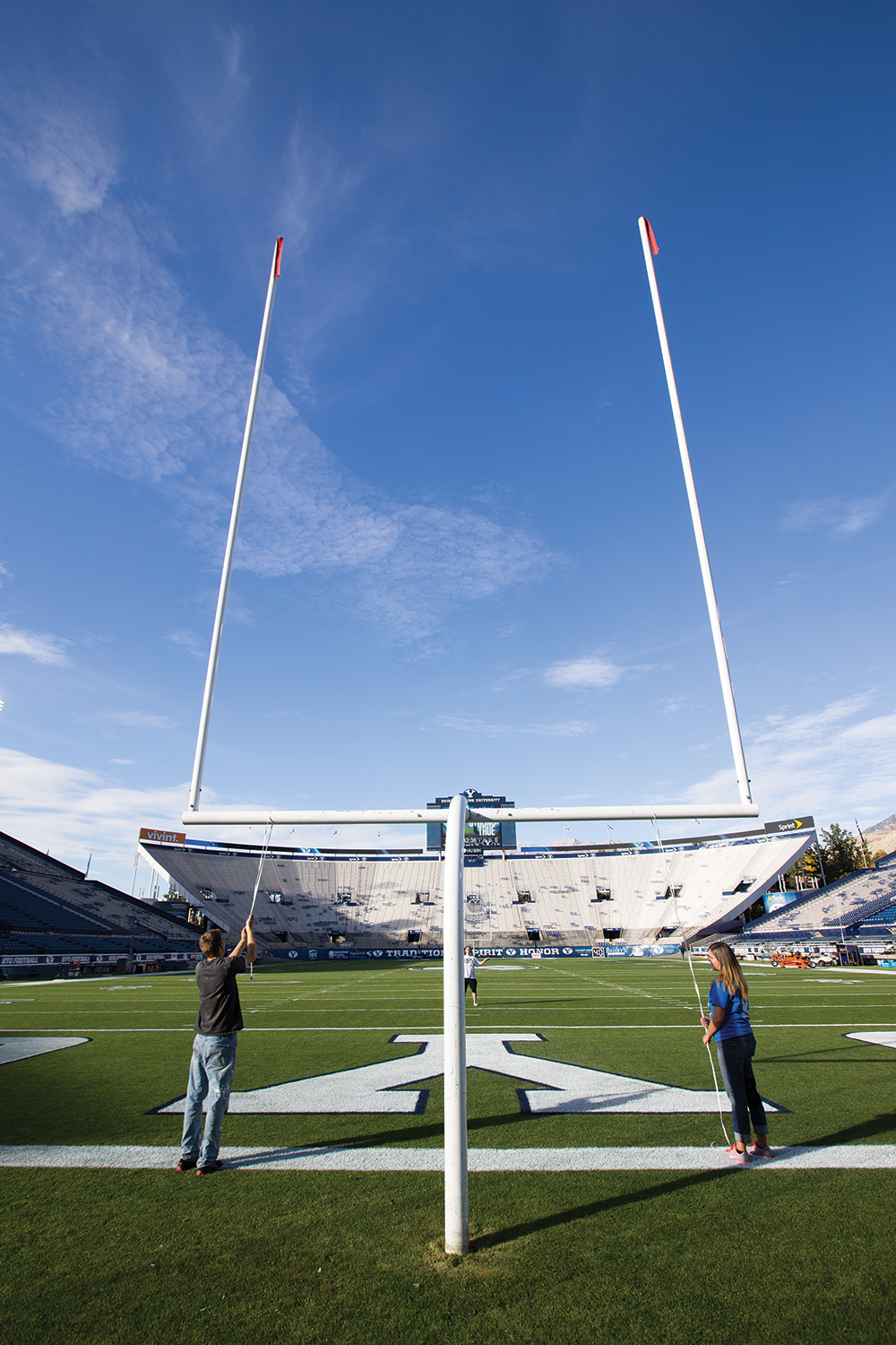 Student employees level the goal posts at LaVell Edwards Stadium before kickoff.