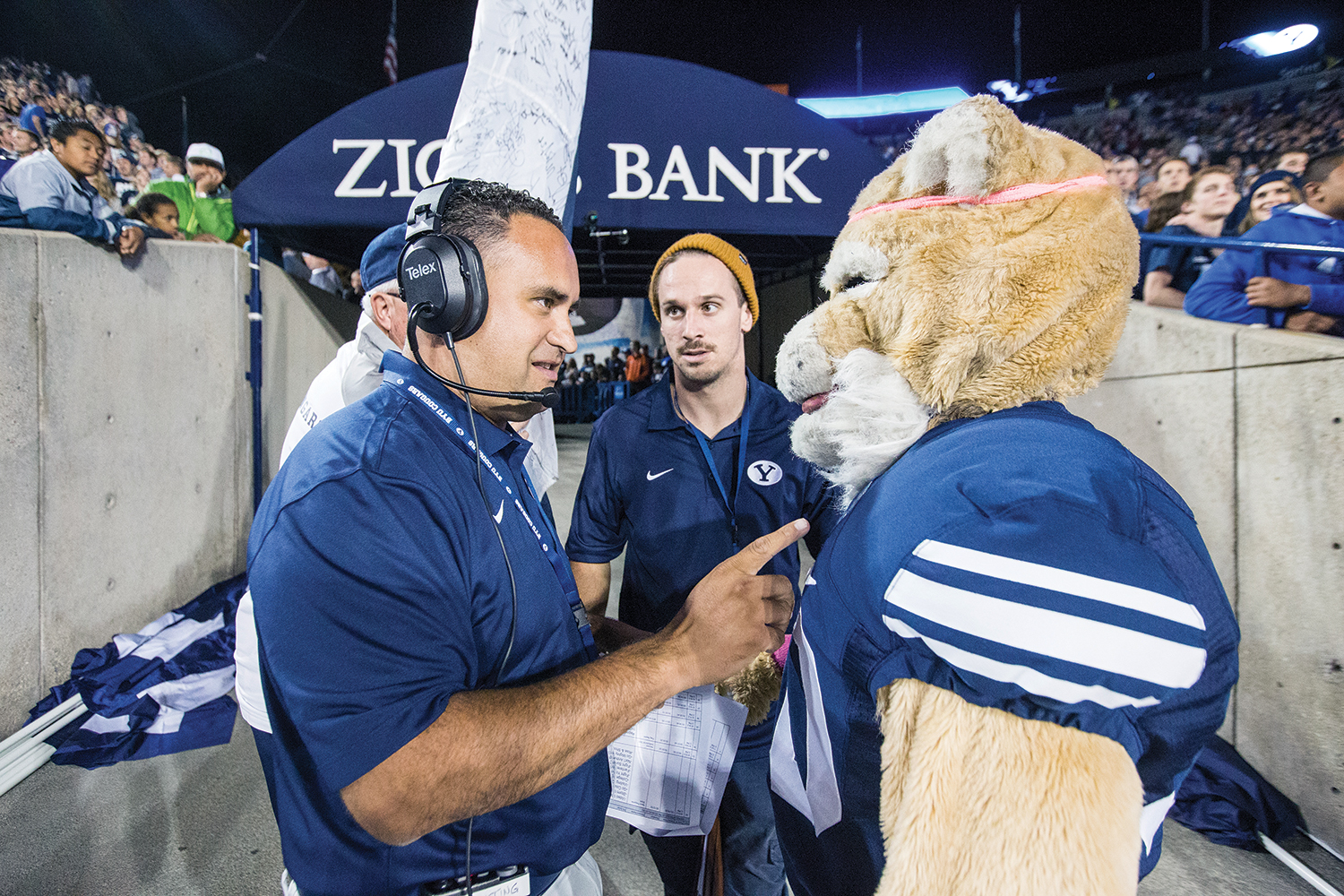Mascot Cosmo receives instructions from a BYU athletics marketing employee.