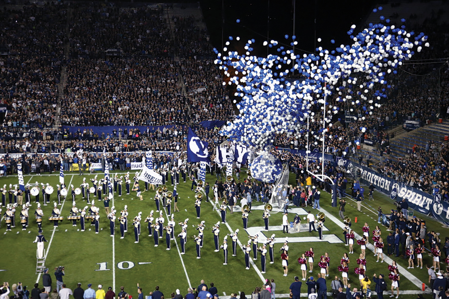 The band plays and thousands of balloons lift into the air as the BYU football team emerges from the tunnel.