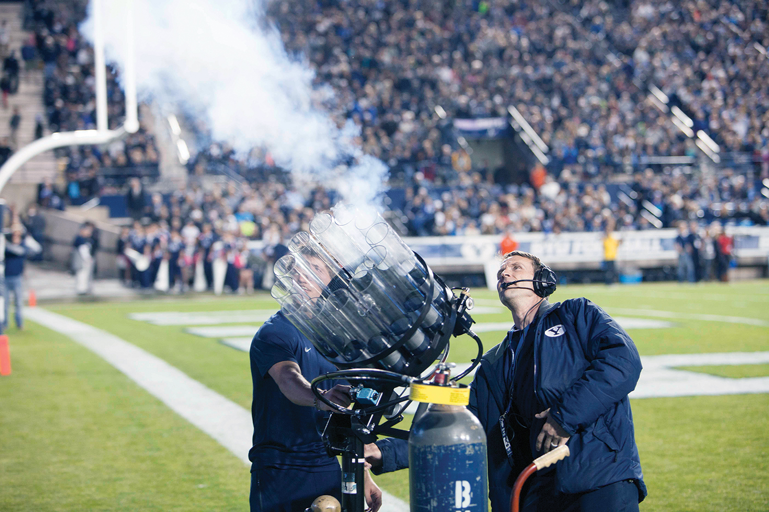 A BYU employee fires shirts into the stadium audience with a gatlin gun-styled launcher.
