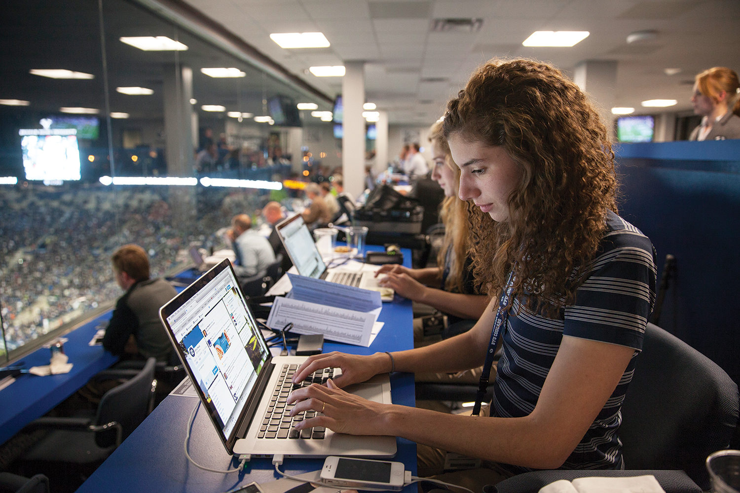 BYU student worker distributes images digitally from BYU's press box.