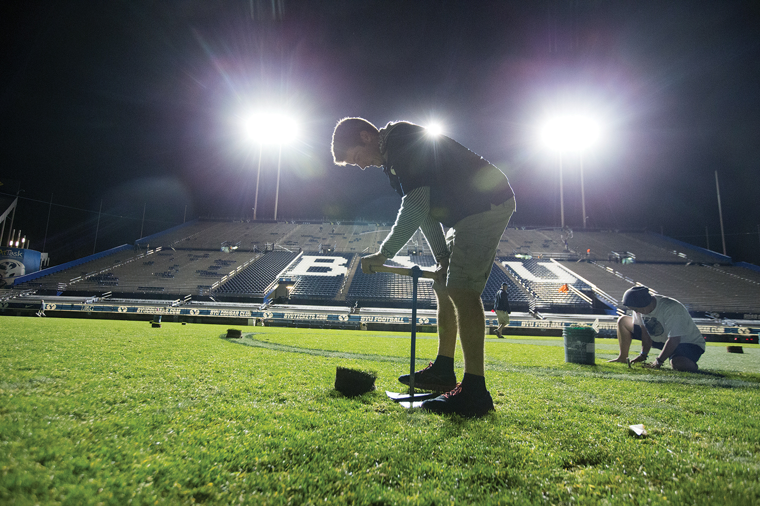 BYU employees make repairs to the turf of the field at LaVell Edwards Stadium following a football game.