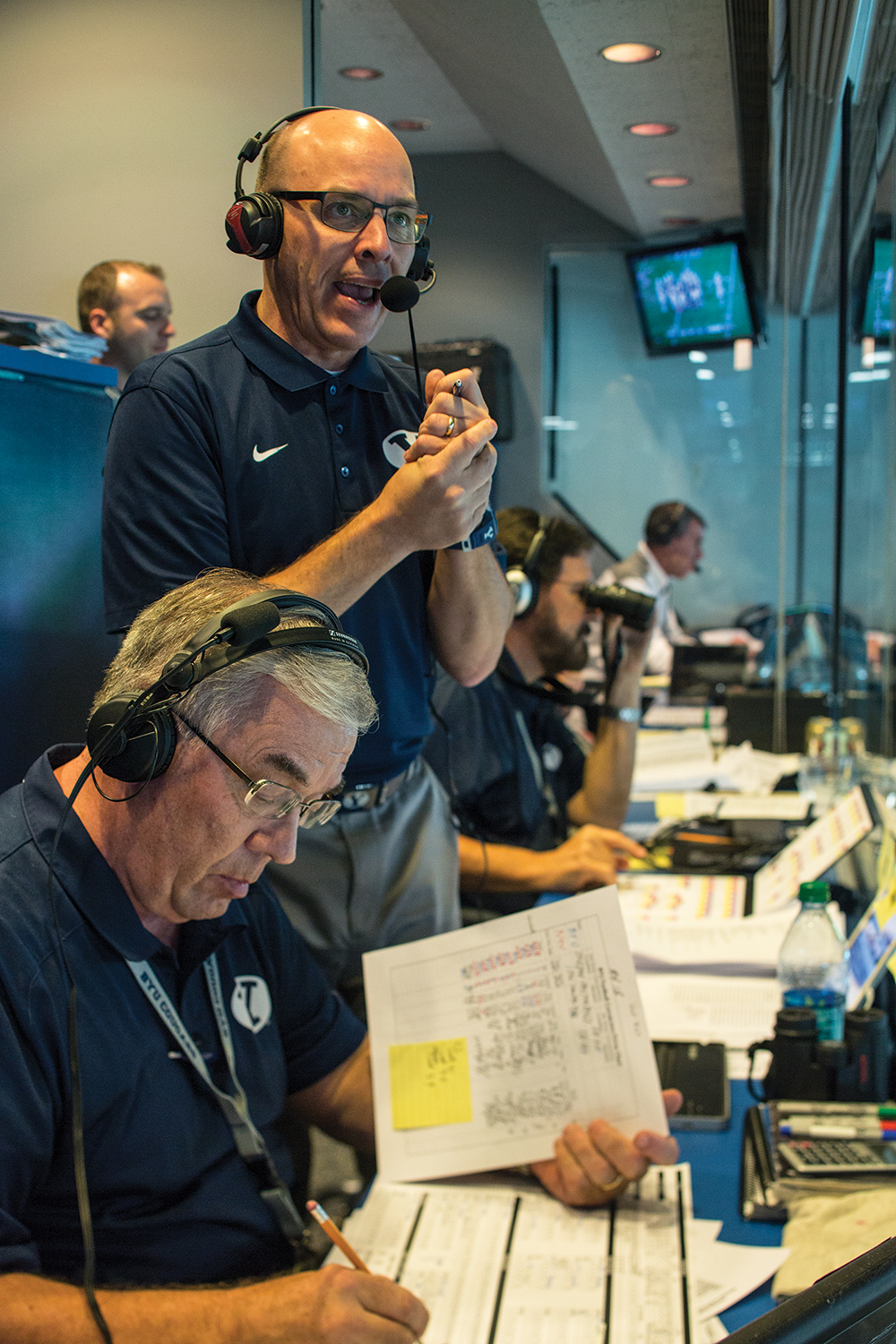 Ralph Sokolowsky, Doug Martin, and Greg Wrubell at work during a football game.