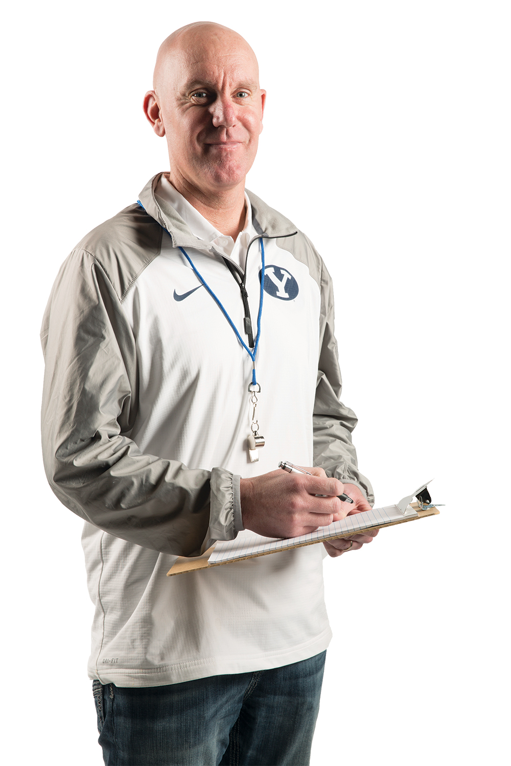 Craig Manning wearing BYU athletic gear and holding a clipboard with a pen.