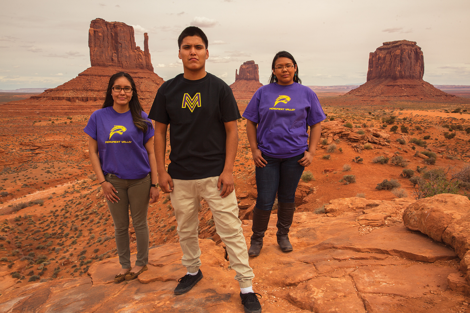 Two girls and a boy sporting their shirts with new logos on red rocks in Southeast Utah.