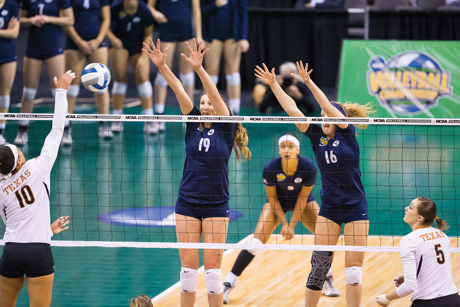 Two BYU women Volleyball players jumping to block the volleyball.