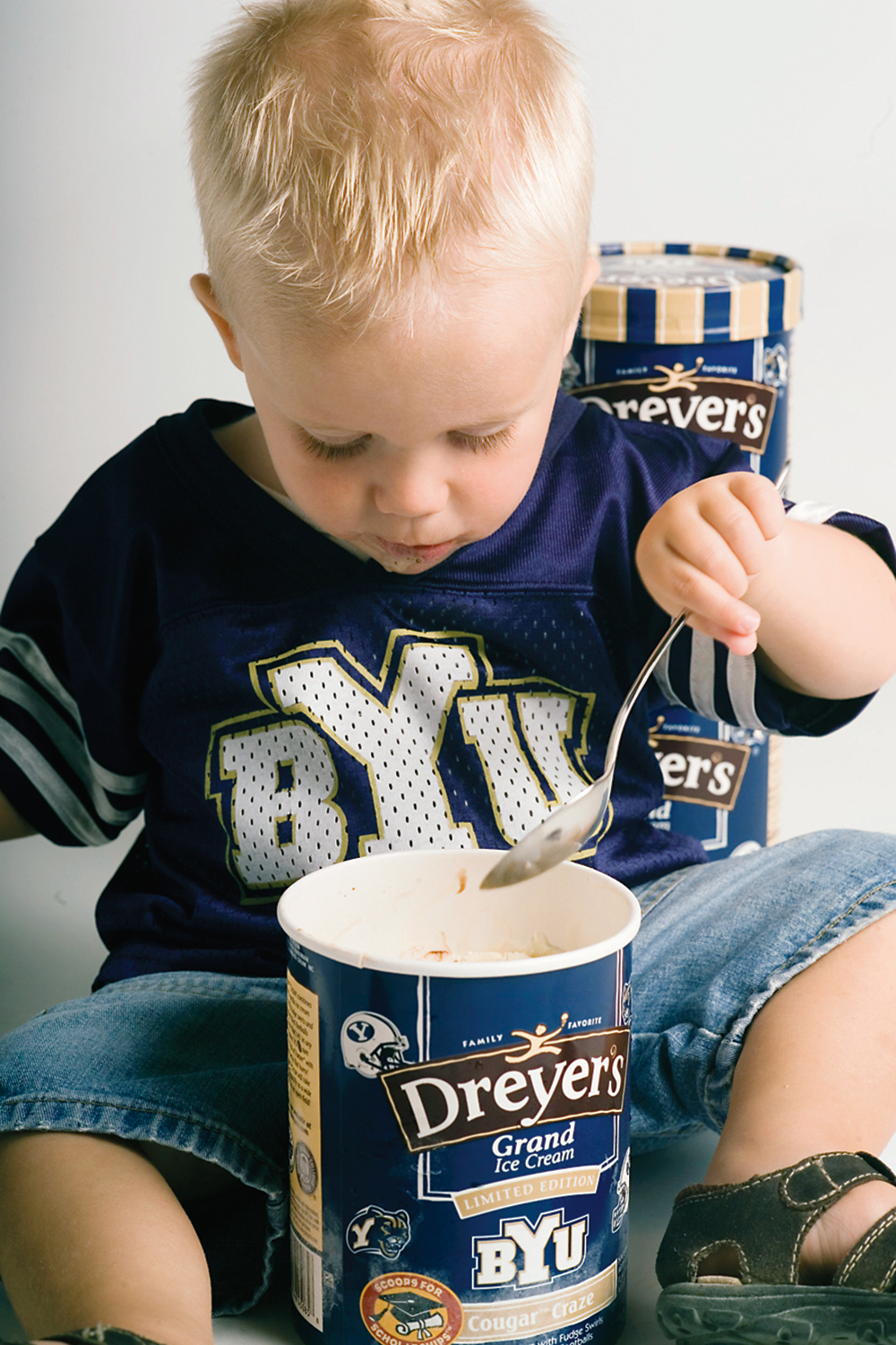 A child eating ice cream straight from the carton.