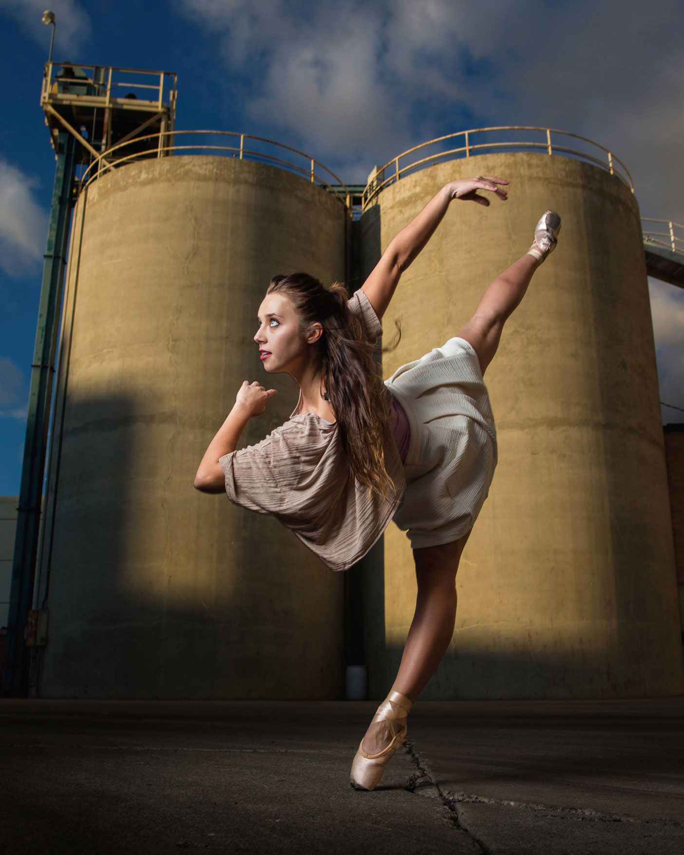 A modern dancer in front of a power plant