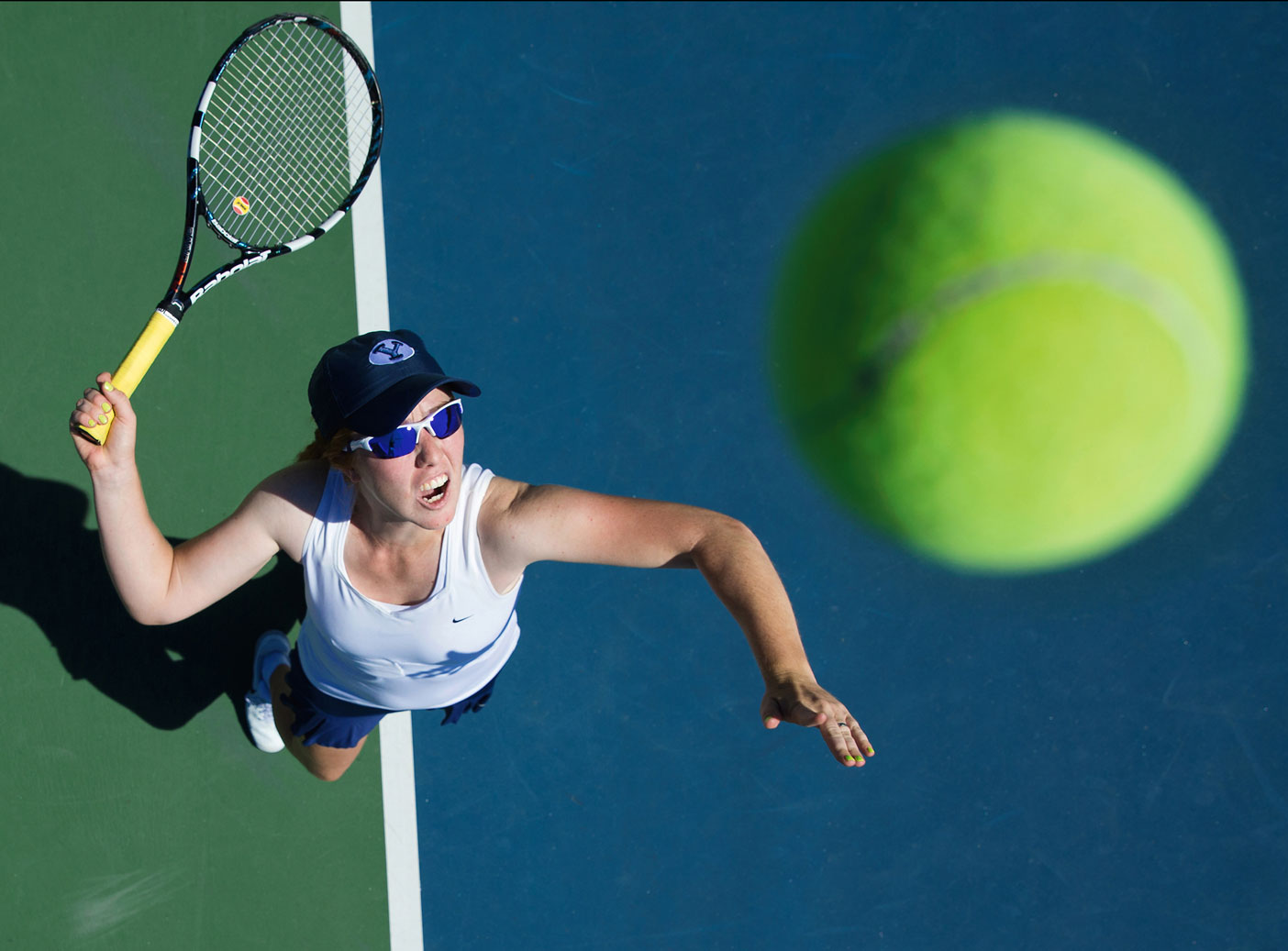 A female athlete tosses up a serve