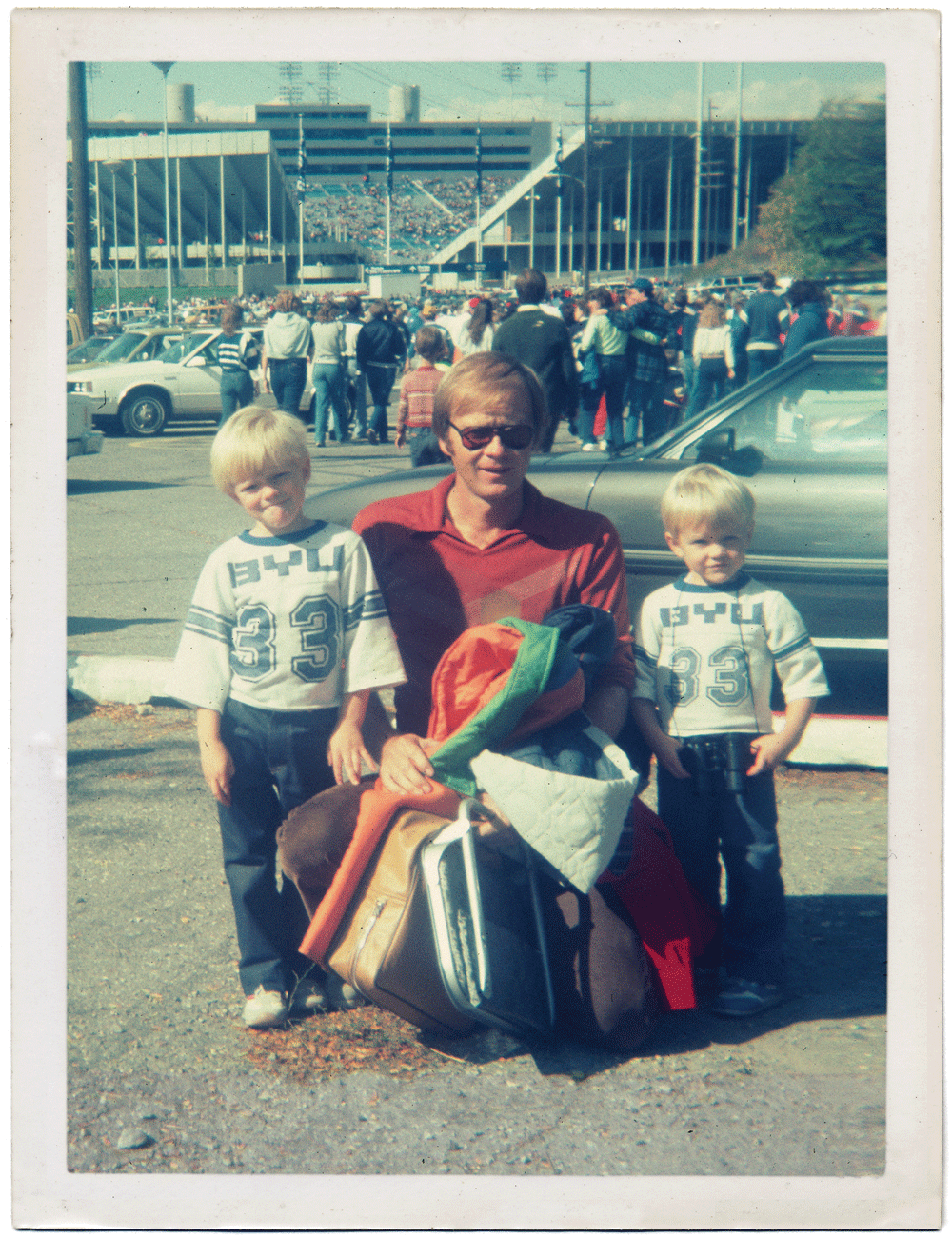 The author’s father, Raymond J. Felix, poses with her brothers at a 1980s home football game.