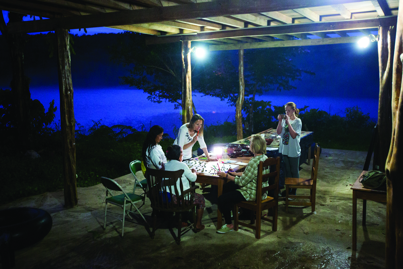 Nuckolls and her students working by lamplight in the evening