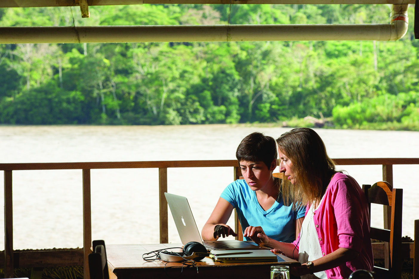 Nuckolls and a student work on a laptop in the open-air field school