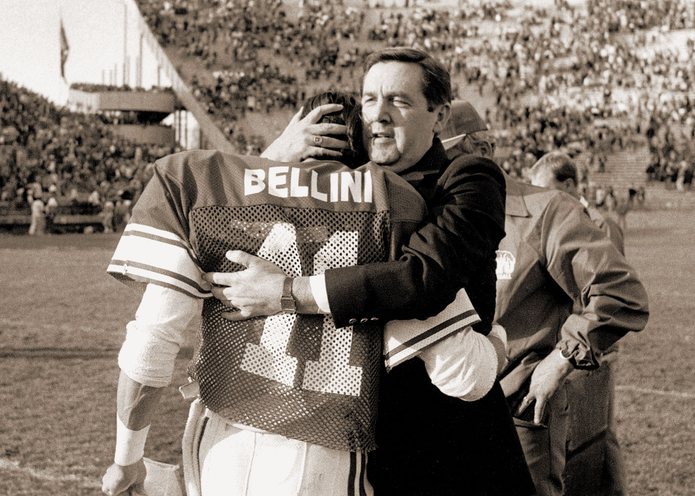 President Jeffrey R. Holland embraces wide receiver Mark J. Bellin during a 1986 football senior ceremony.