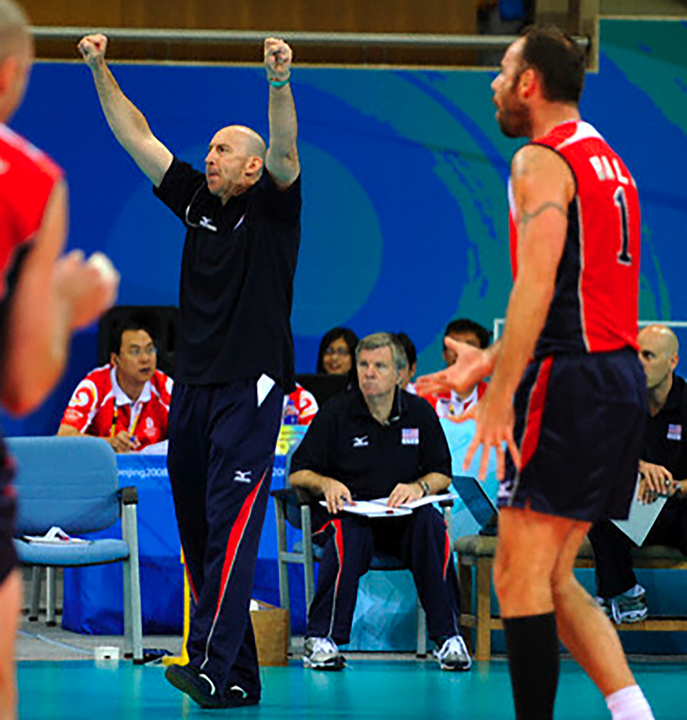 USA head coach Hugh McCutcheo celebrates a point during the final game with Brazil. Assistant coach Larsen (seated) led the team during McCutcheon's absence.