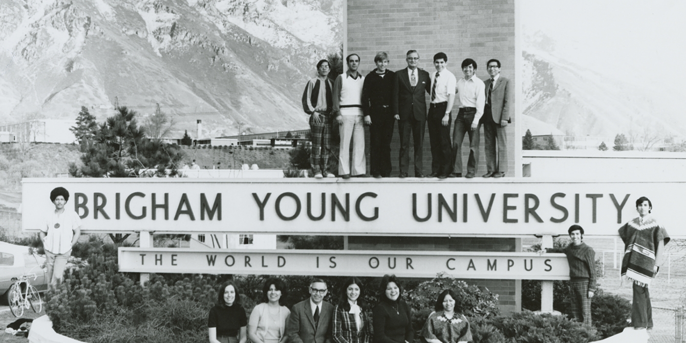 1965 photo of BYU President Ernest L. Wilkinson and BYU students next to the newly erected BYU slogan at the west entrance of campus.