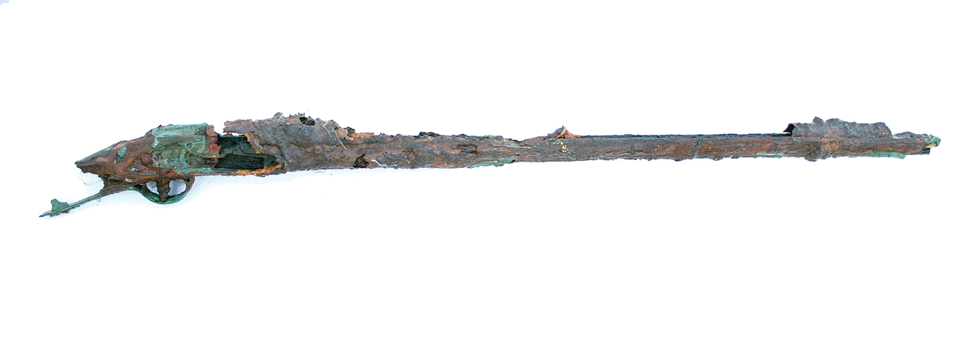 A musket covered in rust and falling apart with the wood splintered and broken.