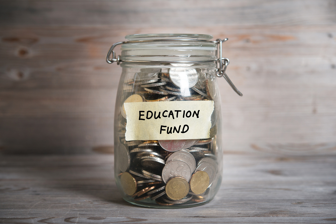 A jar filled with change and labeled "Education Fund"