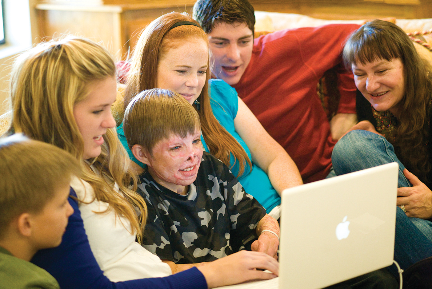 Marius surrounded by friends and family on a couch.