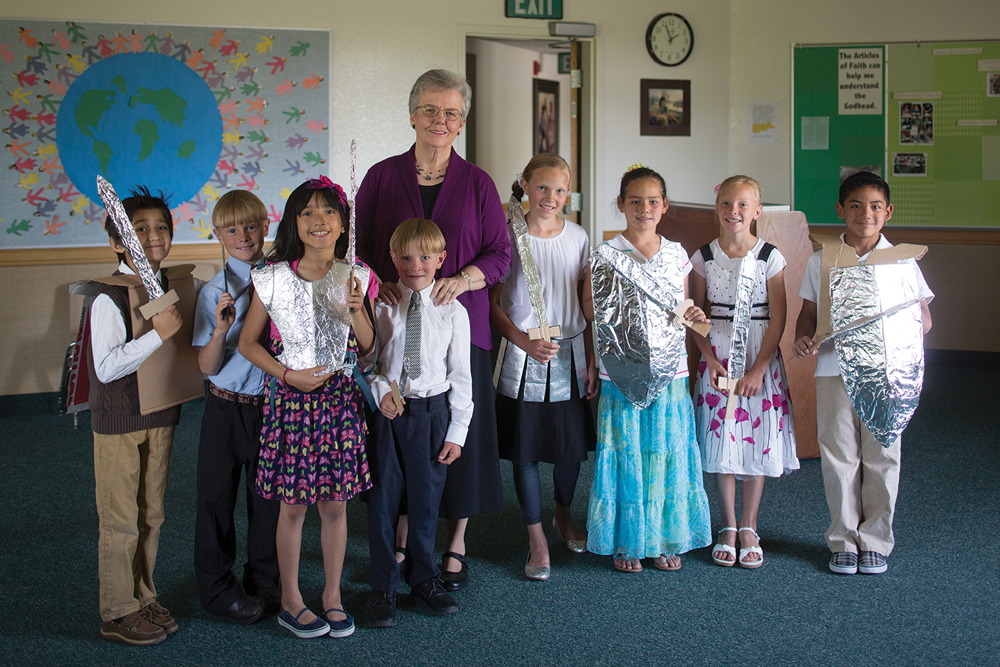 Janice Kapp Perry flanked by children dressed in church clothes and self-crafted aluminum-foil armor.