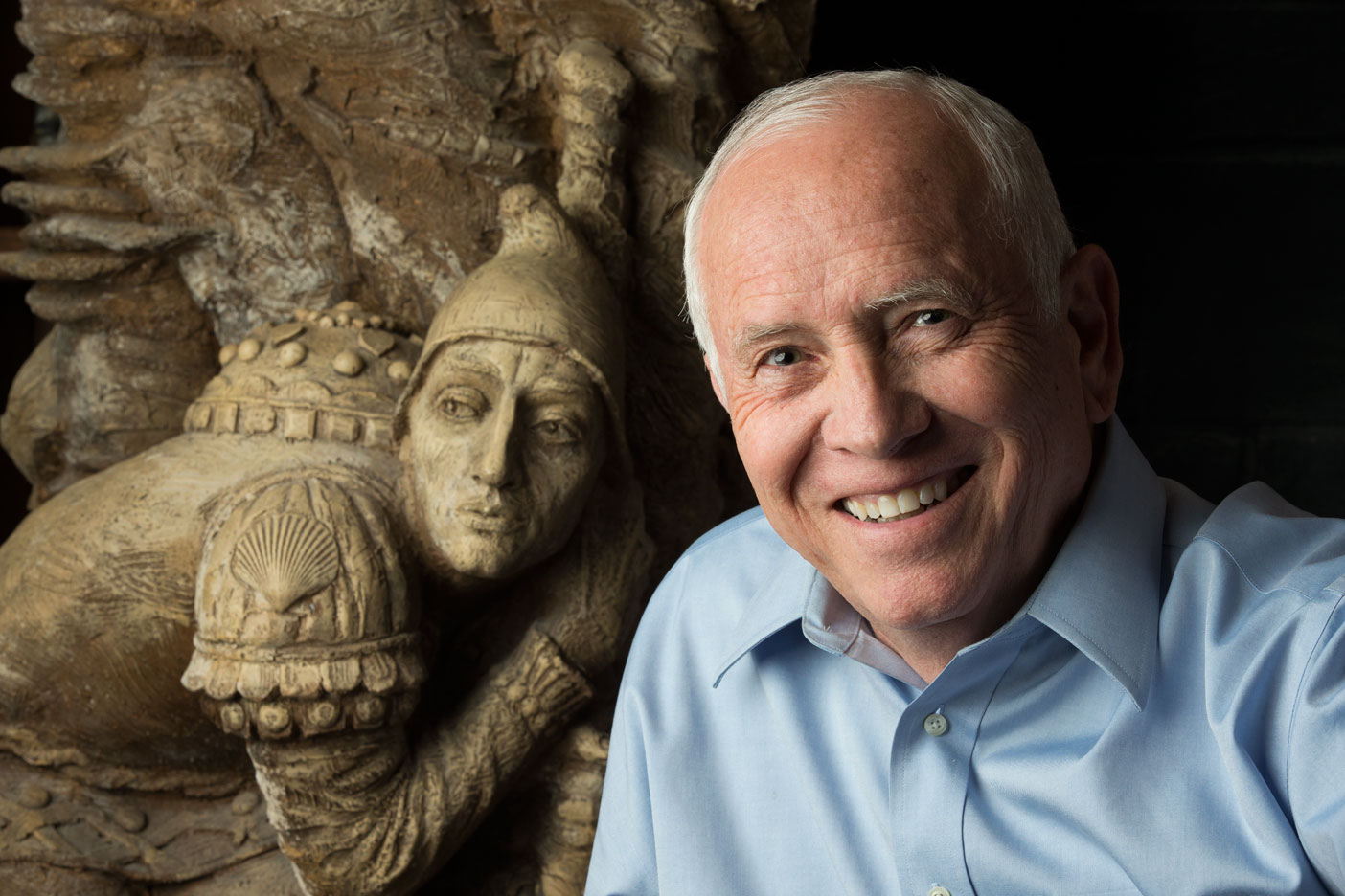 ames Christensen posing by a golden statue