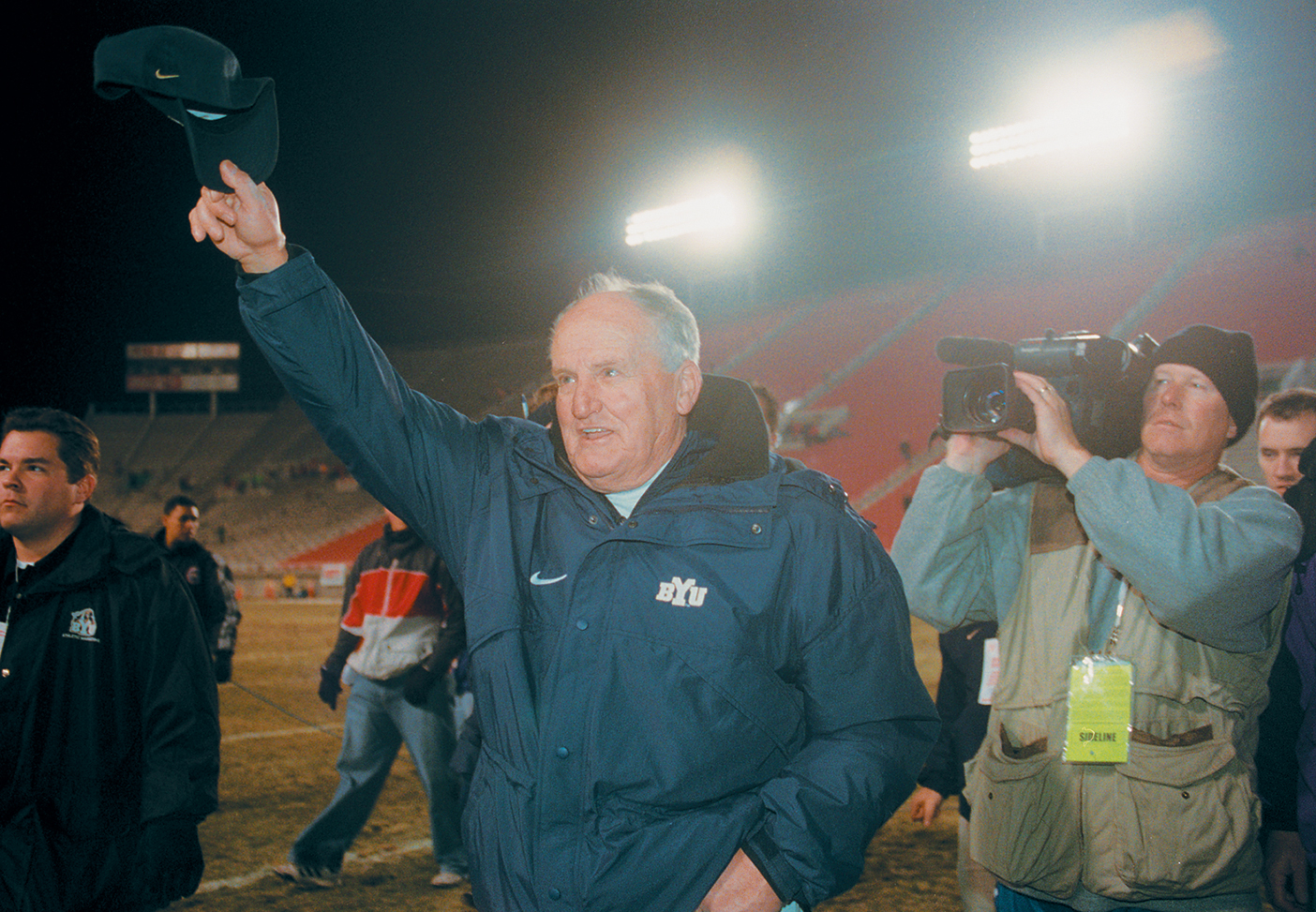 LaVell Edwards waves to fans after a game on the football field