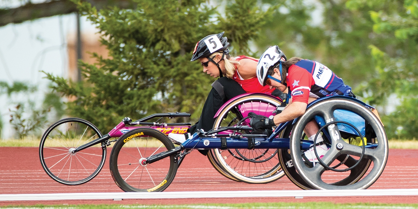 two people in wheelchairs on the track