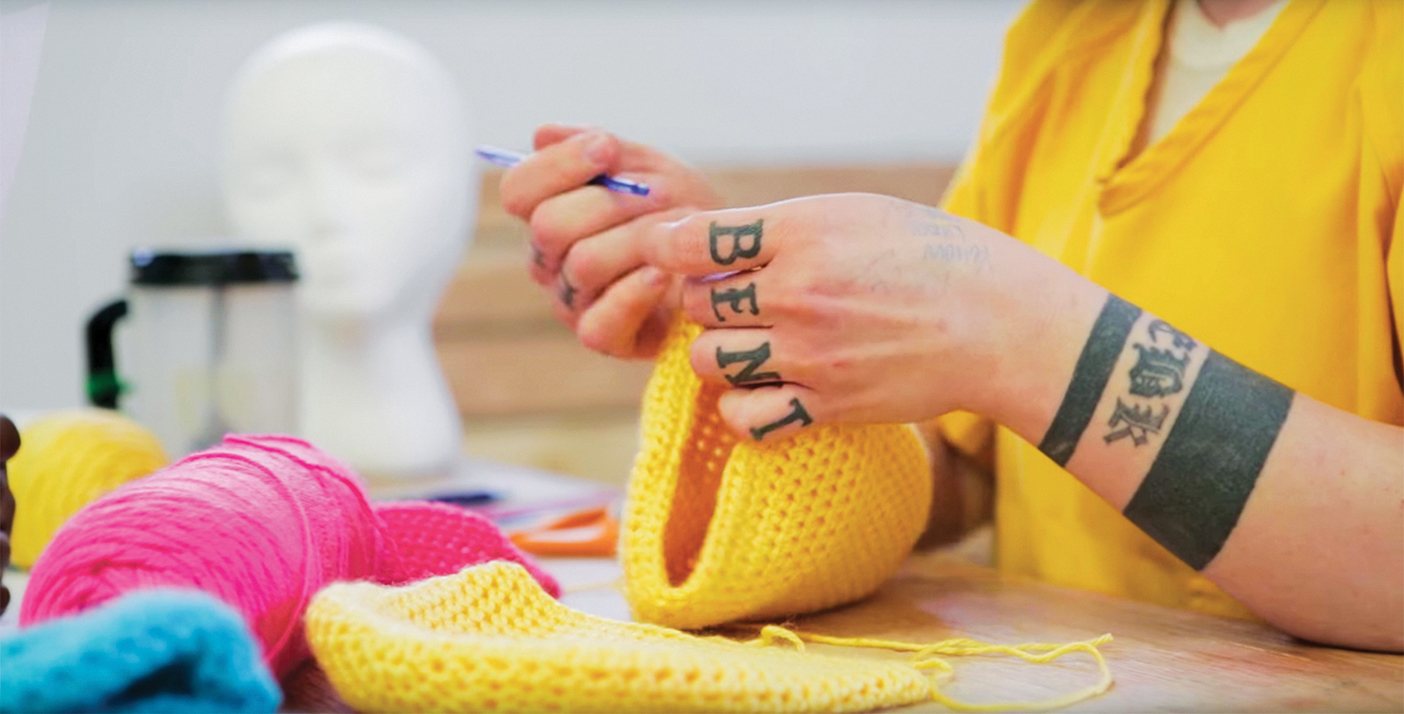 inmate has yellow yarn in her hands