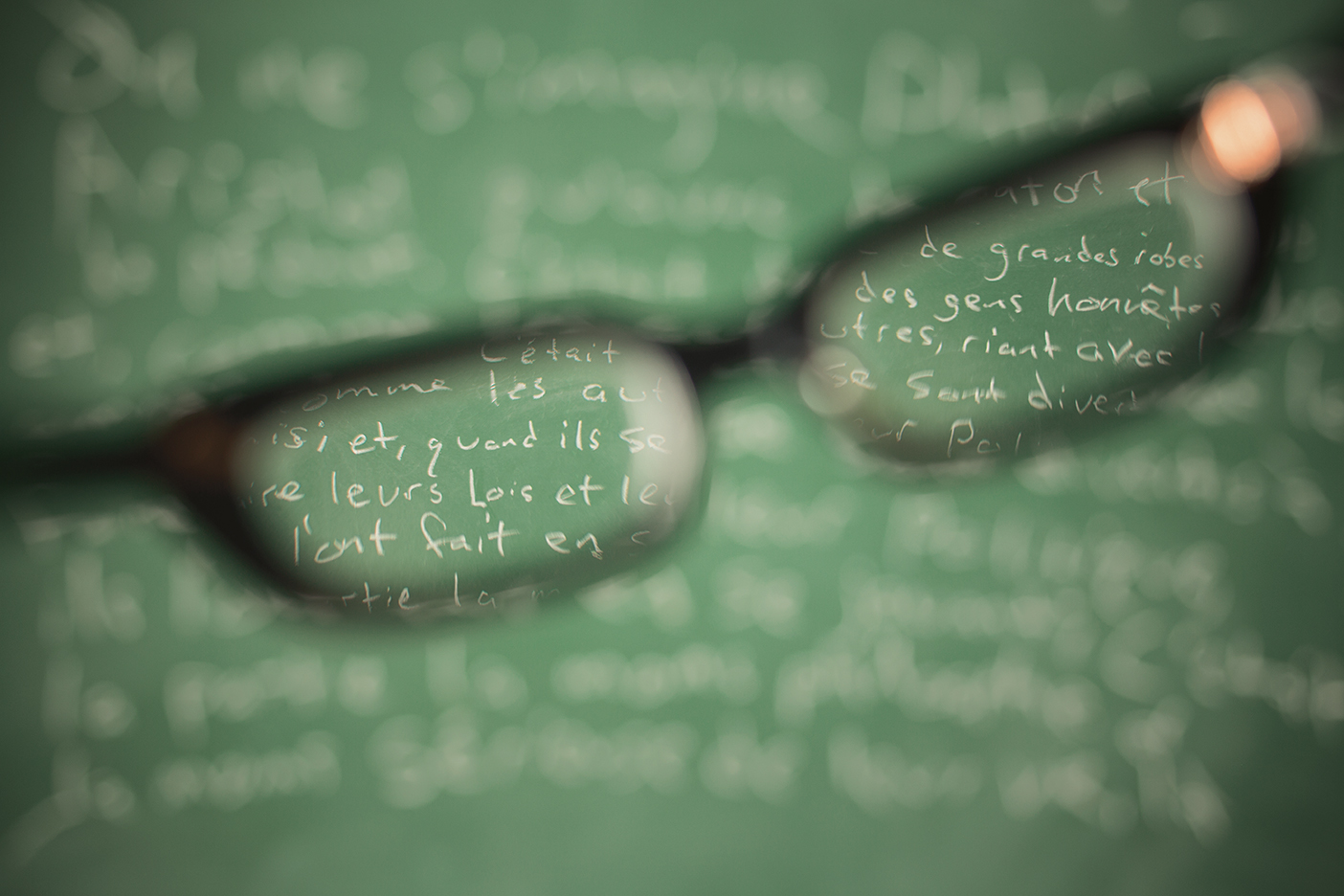 Reading glasses over chalk letters on a chalk board.