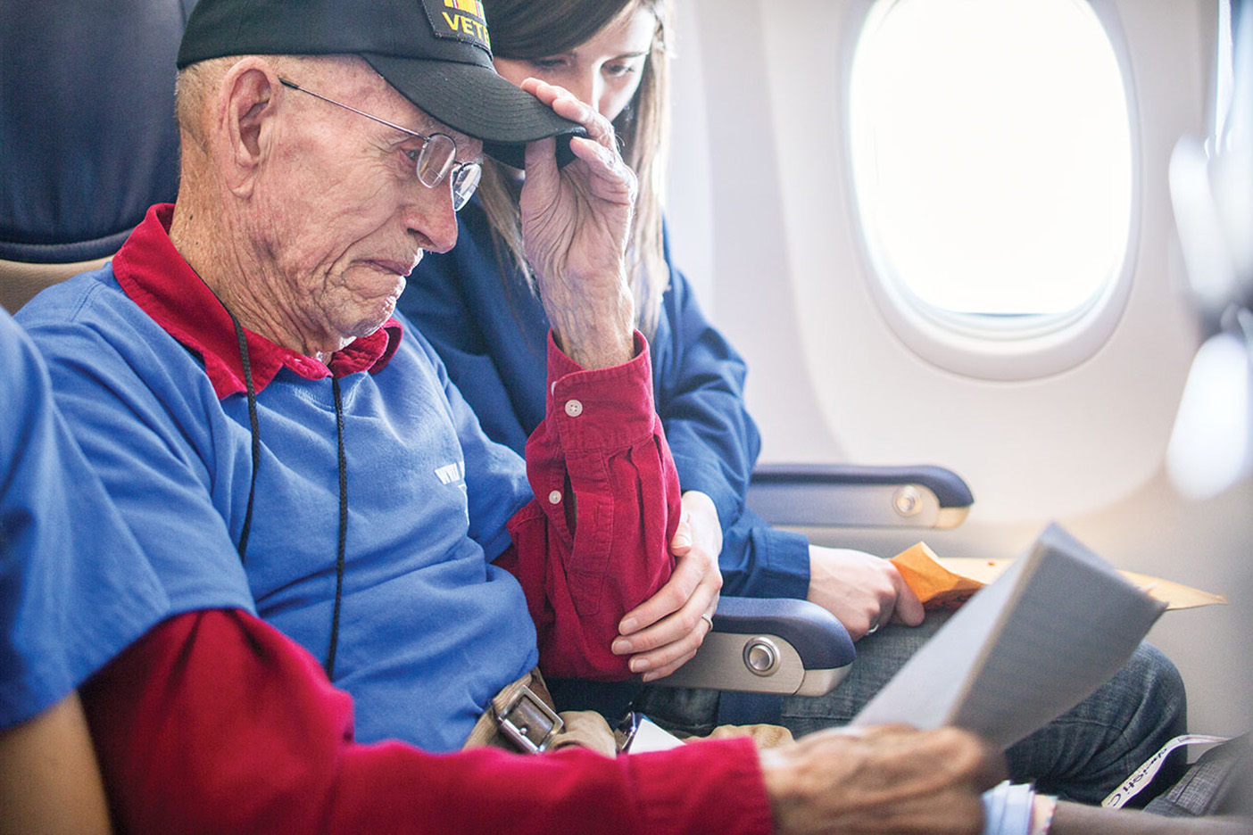 Veteran William Turner and nursing student Christi Swenson reading a letter on the plane.