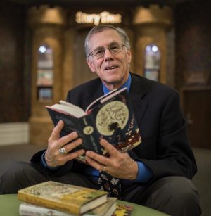 Gene Nelson sitting hold a book
