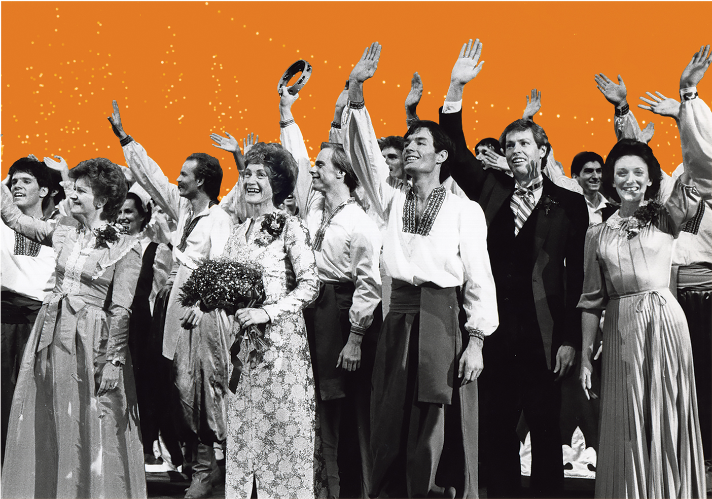 BYU folk dancers wearing costumes and waving after a performance. Mary Bee Jensen is front and center holding a bouquet of flowers.