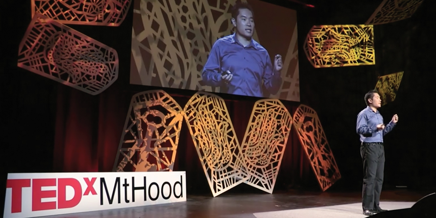 ia Jang on stage at TEDxMount Hood where he speaks to an audience about rejection