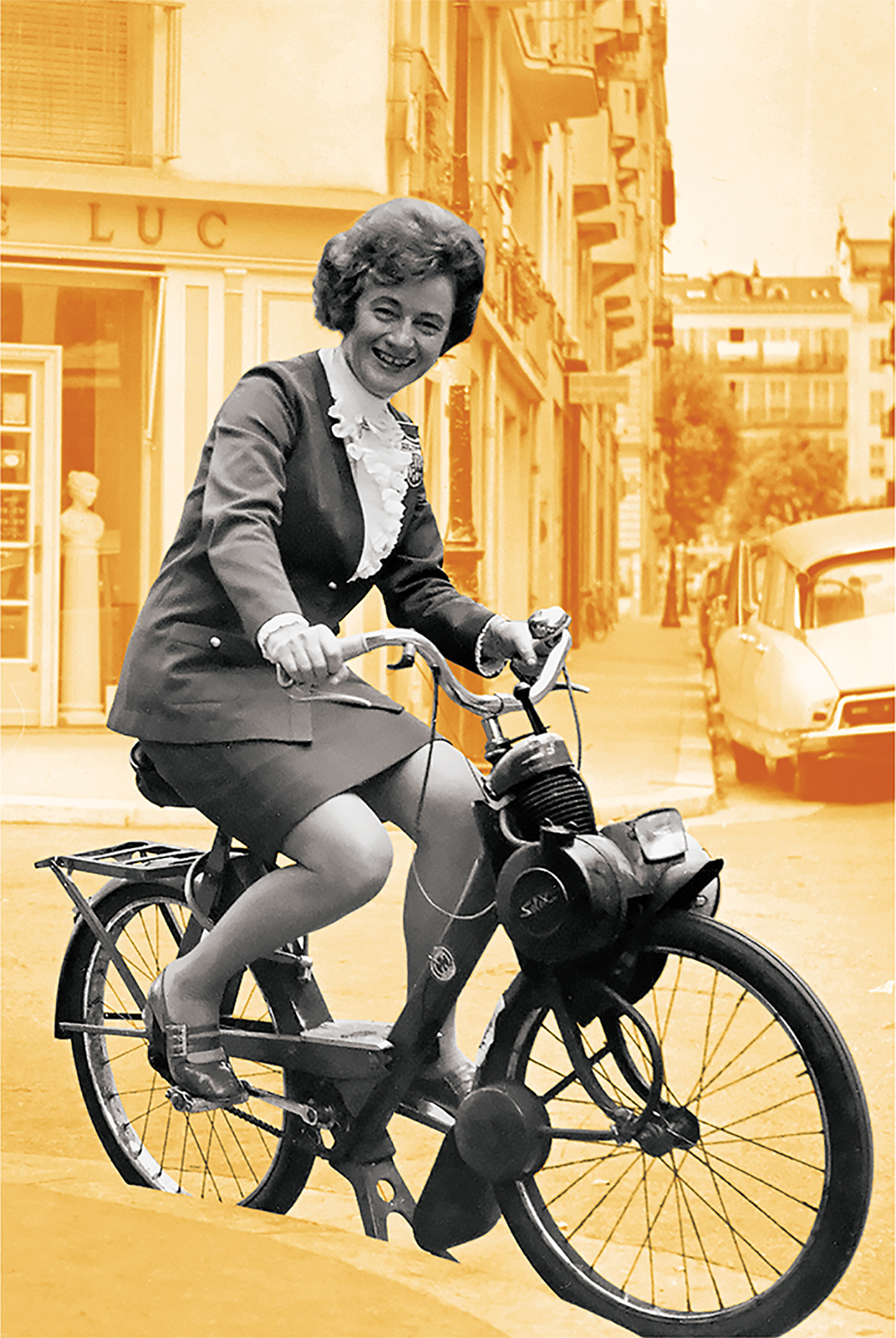 Mary Bee Jensen smiling while riding a bike down the street